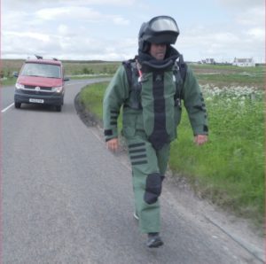 Si walking in the bomb suit